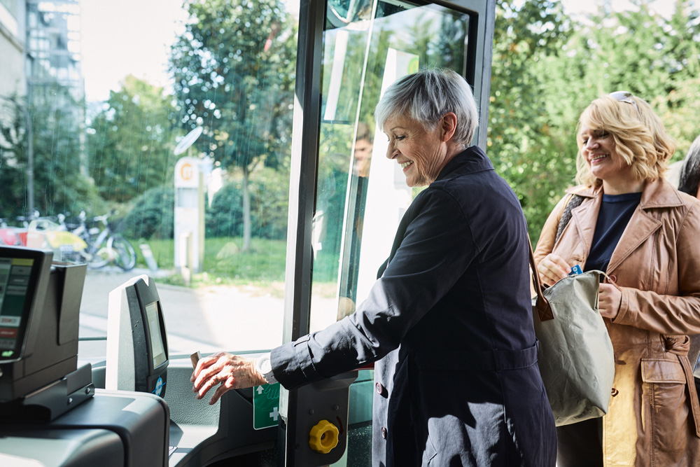 Eine ältere Dame steigt in den Bus ein